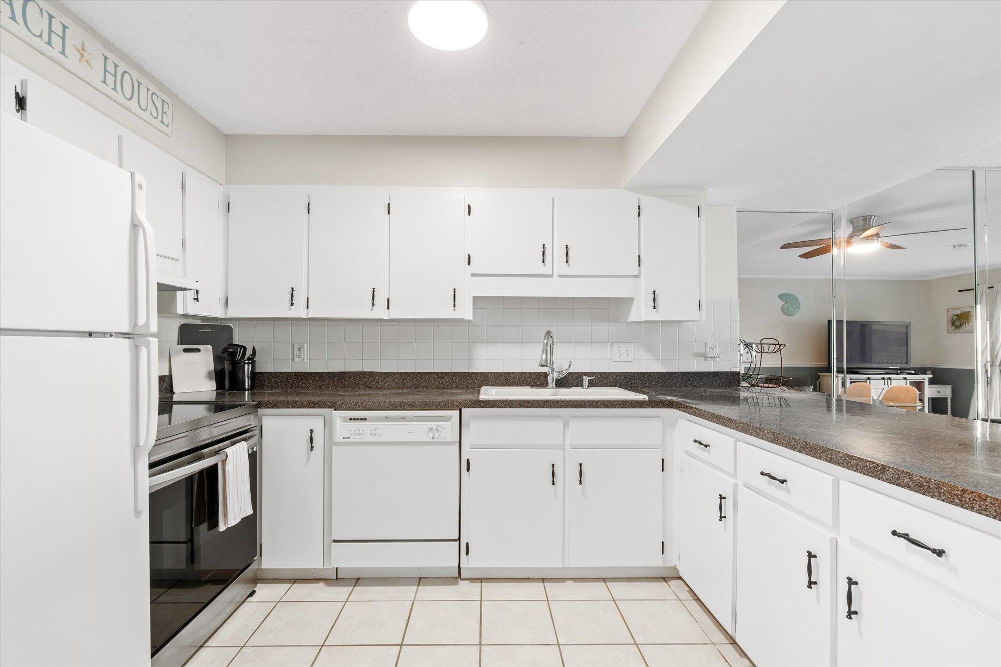 1 Ocean Trace Road, Unit 242 St. Augustine, FL 32080 - Photo 5 of 66 a white kitchen with granite countertop white cabinets and white appliances