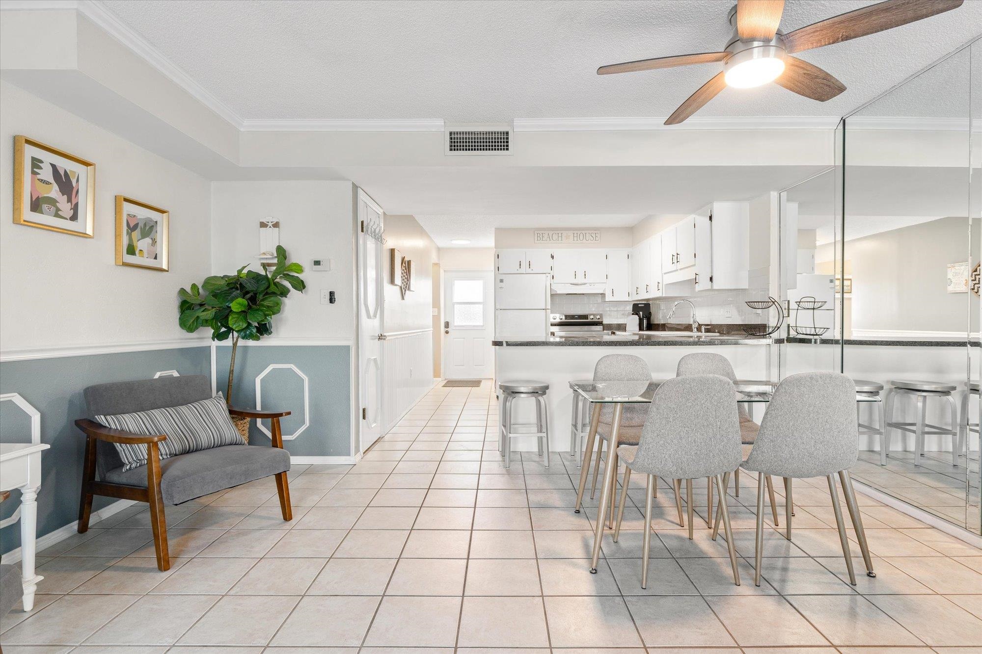 1 Ocean Trace Road, Unit 242 St. Augustine, FL 32080 - Photo 7 of 66 a kitchen with stainless steel appliances kitchen island granite countertop a table chairs and a refrigerator