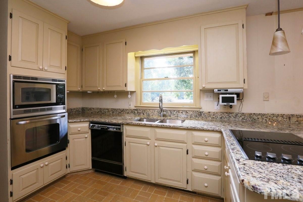 1913 Highland Place Raleigh, NC 27607 - Photo 8 of 25 a kitchen with granite countertop a sink stainless steel appliances and cabinets