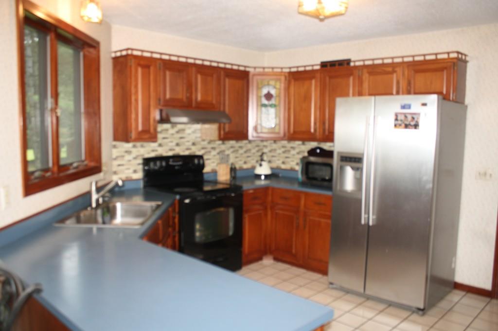 82 Stillwater Road Deerfield, MA 01373 - Photo 6 of 22 a kitchen with stainless steel appliances granite countertop a refrigerator a stove and a sink with wooden cabinets