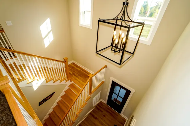 a kitchen with stainless steel appliances granite countertop a sink a stove a refrigerator and island with wooden floor