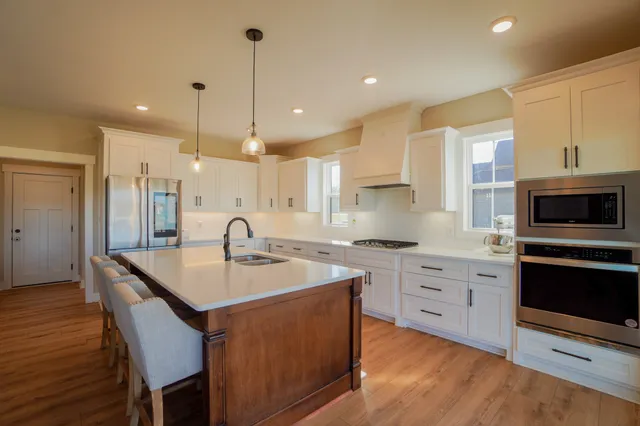 a kitchen with a sink stove and wooden floor