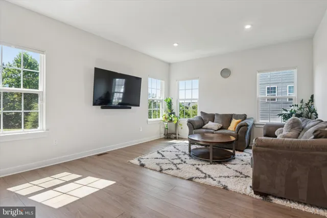 a living room with furniture a flat screen tv and a window