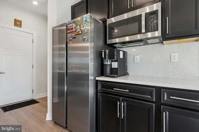 a kitchen with stainless steel appliances a refrigerator and a microwave