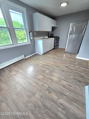 a view of kitchen with sink microwave and cabinets