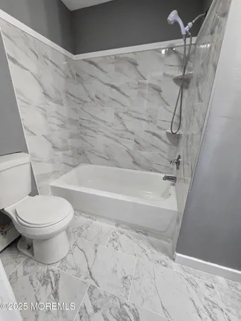 a bathroom with a toilet and a shower