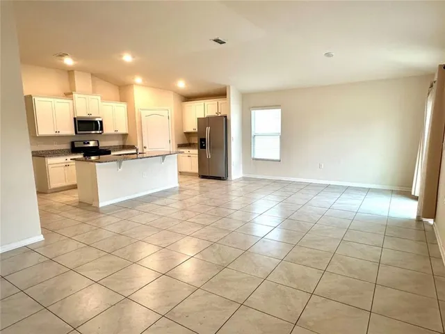 a kitchen with stainless steel appliances a sink a stove a microwave a counter top space and cabinets