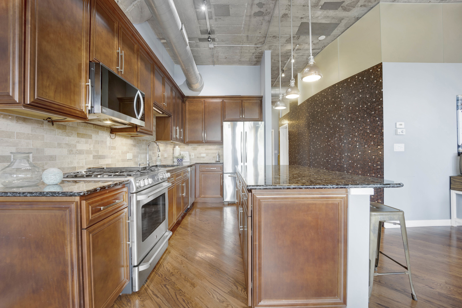 1069 West 14th Place, Unit 323 Chicago, IL 60608 - Photo 11 of 43 a kitchen with stainless steel appliances granite countertop a stove a sink and a microwave