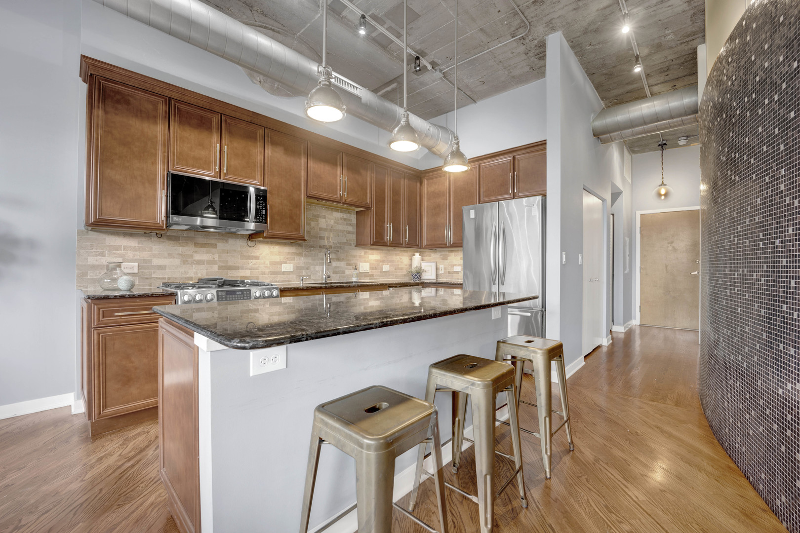 1069 West 14th Place, Unit 323 Chicago, IL 60608 - Photo 12 of 43 a kitchen with stainless steel appliances granite countertop a stove top oven a sink and a microwave