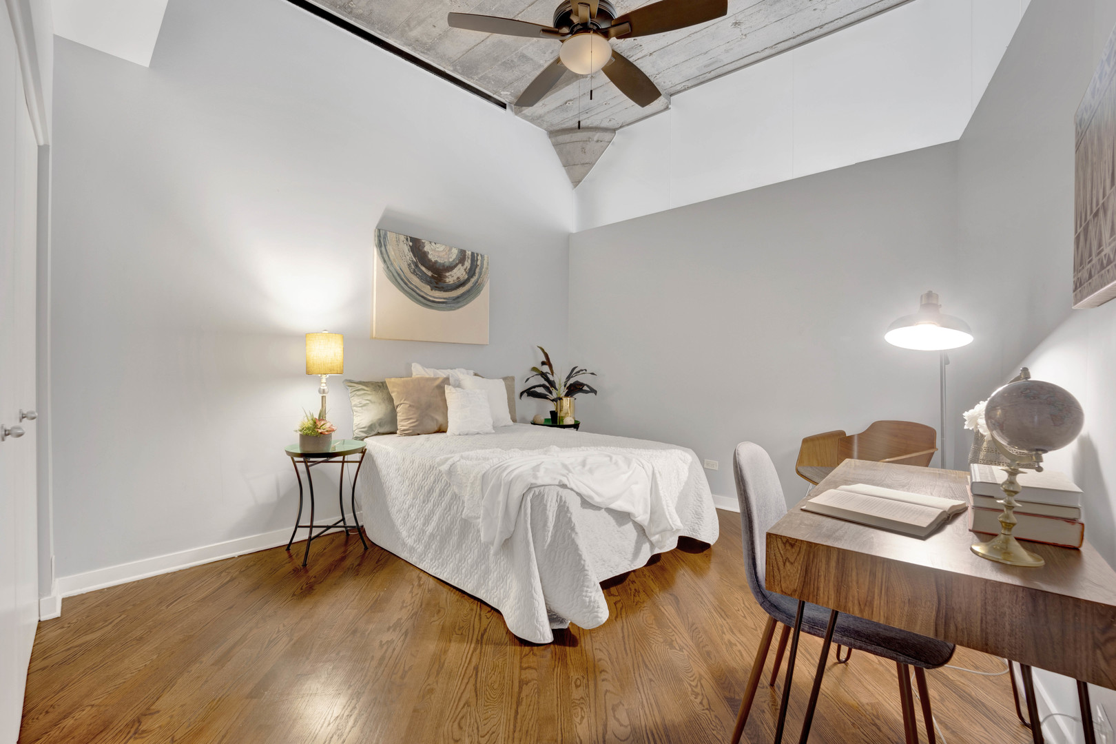 1069 West 14th Place, Unit 323 Chicago, IL 60608 - Photo 22 of 43 a bedroom with a bed and dresser with wooden floor