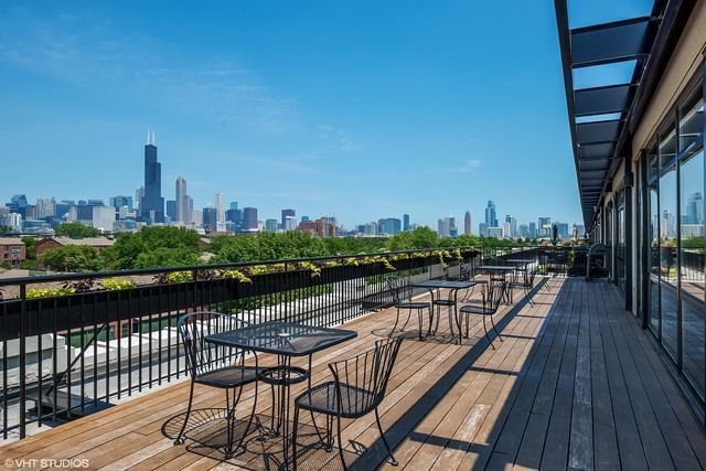 1069 West 14th Place, Unit 323 Chicago, IL 60608 - Photo 36 of 43 a view of a balcony with wooden chairs
