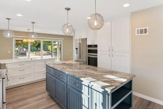 a kitchen with stainless steel appliances granite countertop a stove a sink and a wooden floor