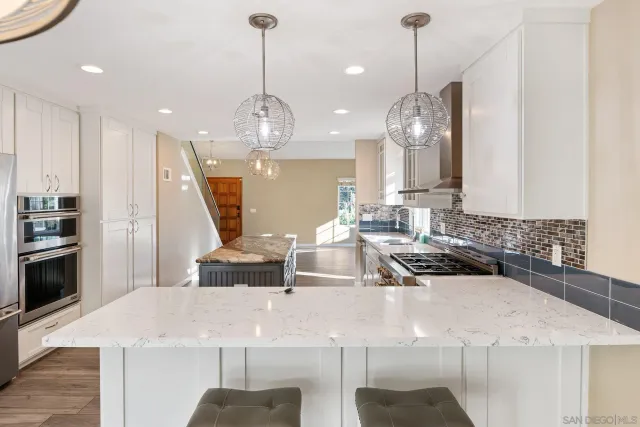 a kitchen with kitchen island granite countertop a sink cabinets and wooden floor