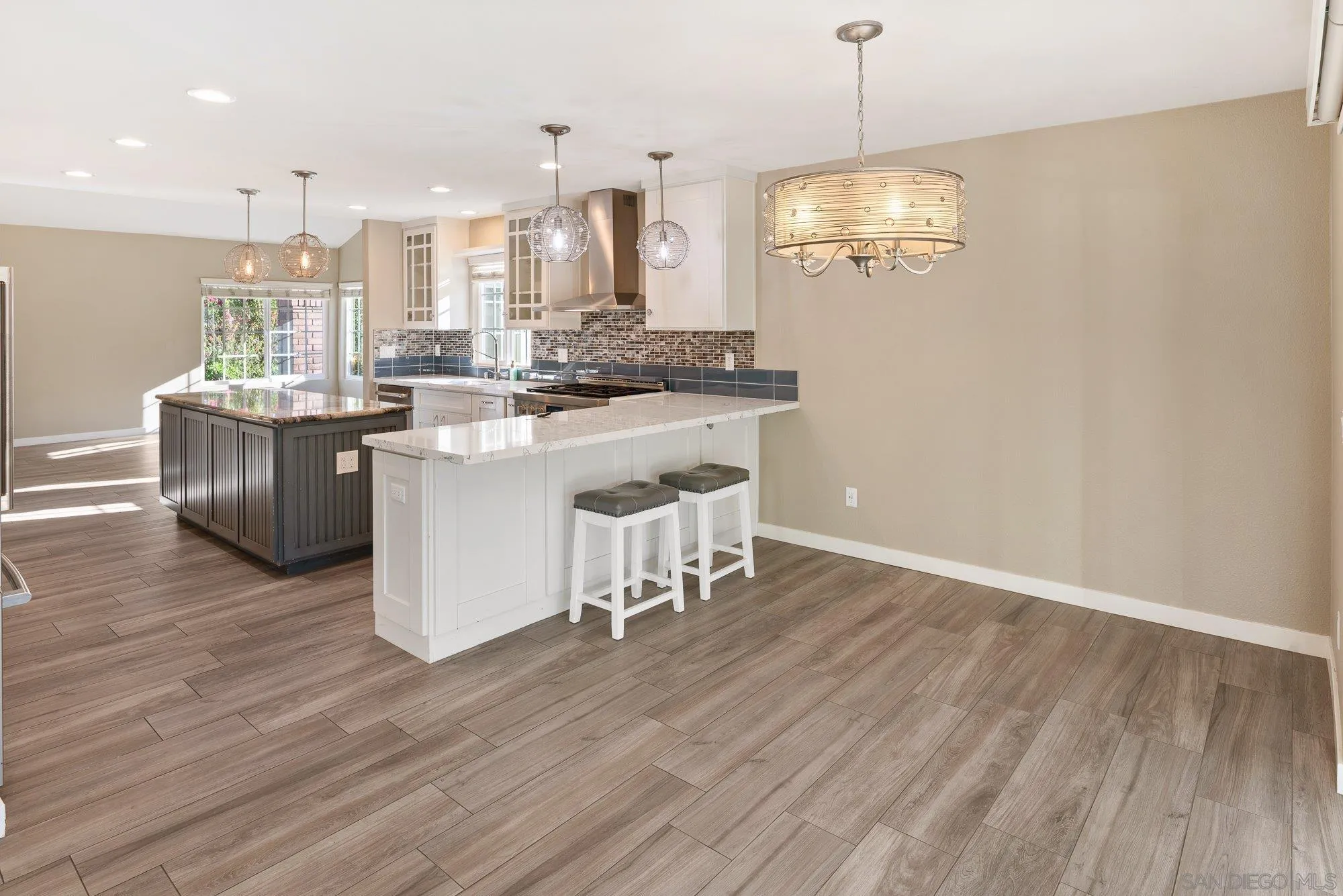 14274 Woodcreek Road Poway, CA 92064 - Photo 16 of 57 a kitchen with kitchen island granite countertop a sink cabinets and wooden floor