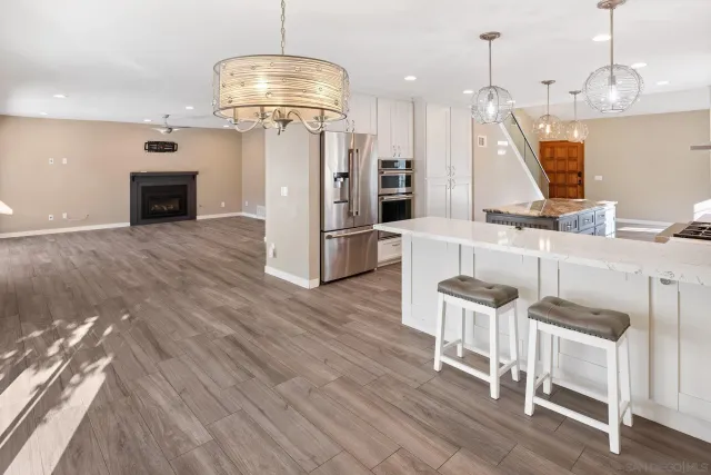 an empty room with wooden floor fireplace and windows