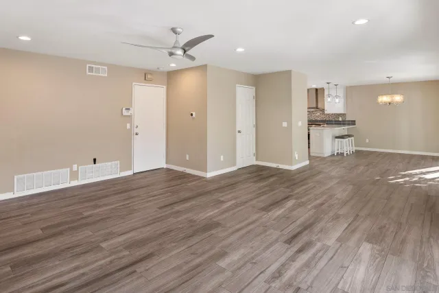 a view of a livingroom with wooden floor and furniture