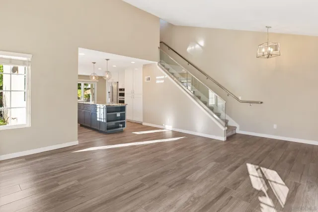 a large kitchen with granite countertop a large counter top space a sink stainless steel appliances and cabinets