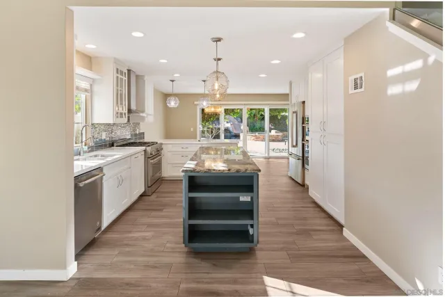 a kitchen with a sink stove and wooden floor