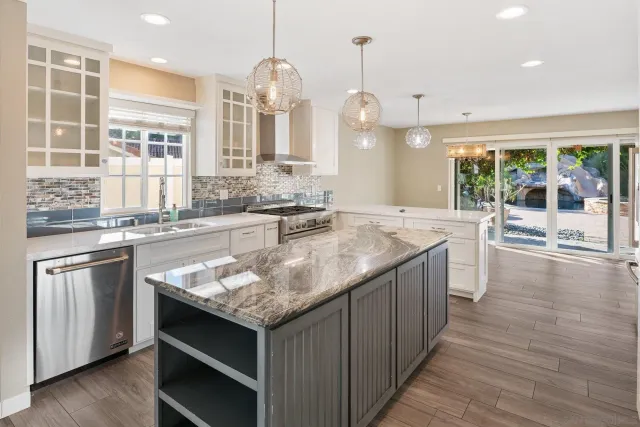 a kitchen with a stove and a wooden floor