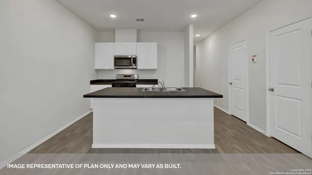 a kitchen with stainless steel appliances granite countertop a sink stove and microwave