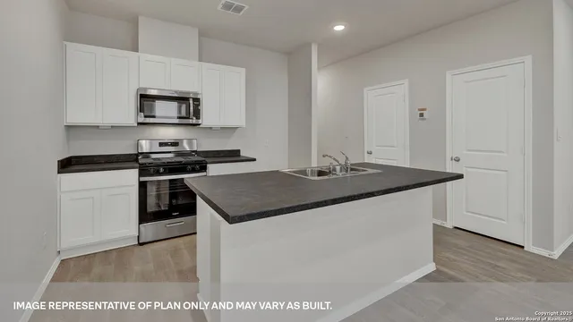 a kitchen with a sink cabinets and wooden floor