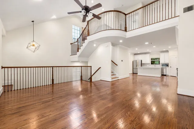 a view of a hallway with wooden floor and staircase