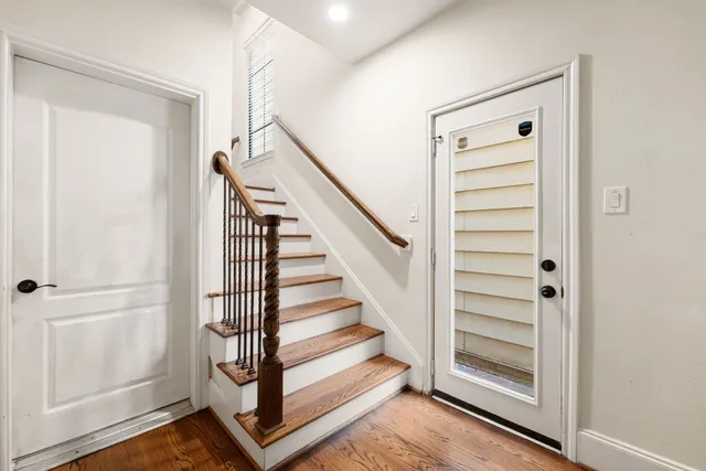 a view of a hallway with wooden floor and entryway