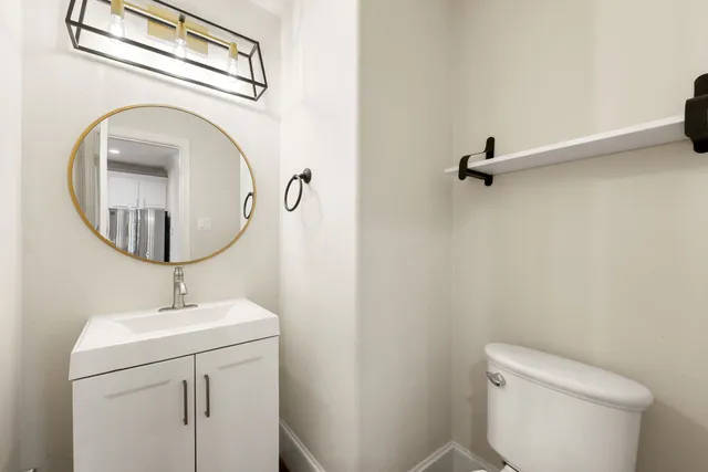 a bathroom with a toilet a sink and a mirror