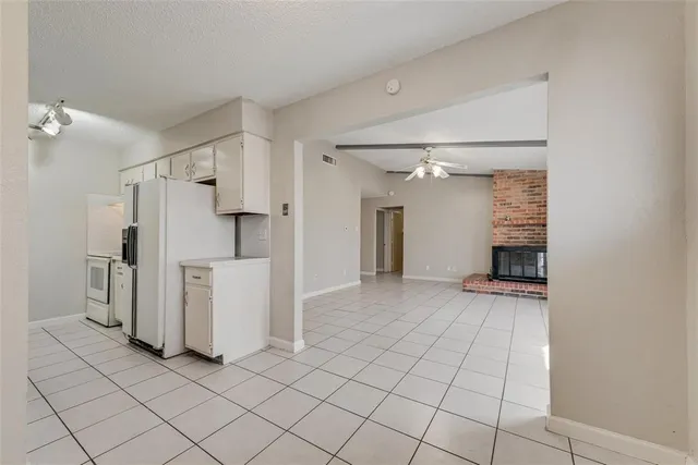 a view of a storage & utility room with refrigerator and window