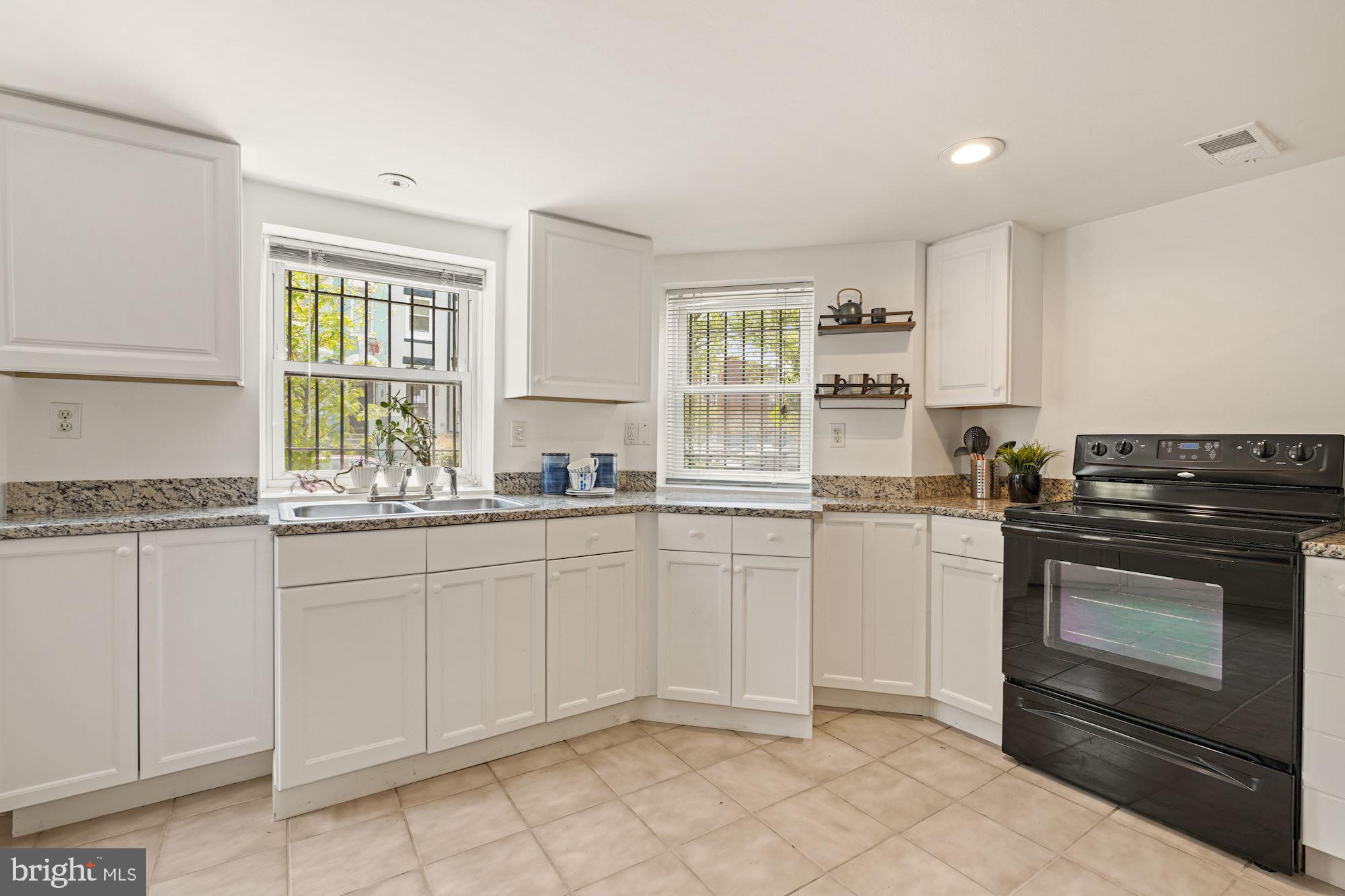 3001 13th Street Northwest, Unit B Washington, DC 20009 - Photo 6 of 11 a kitchen with granite countertop white cabinets and appliances