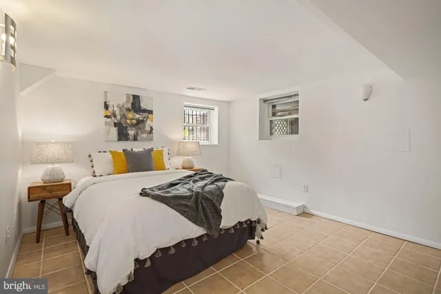 a bedroom with a bed and a painting on the wall