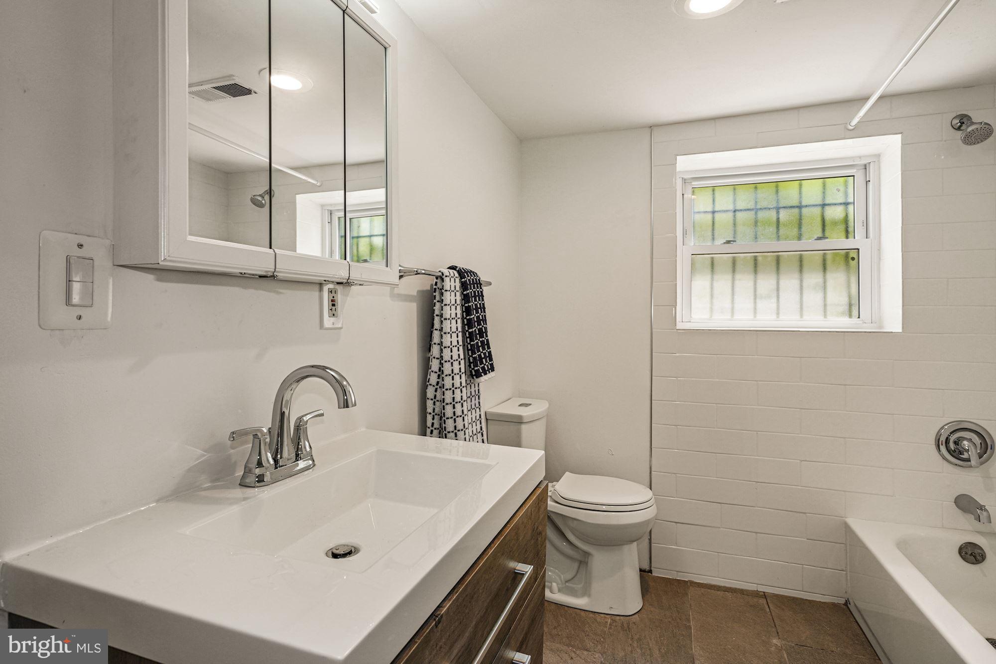 3001 13th Street Northwest, Unit B Washington, DC 20009 - Photo 9 of 11 a bathroom with a sink a toilet and shower