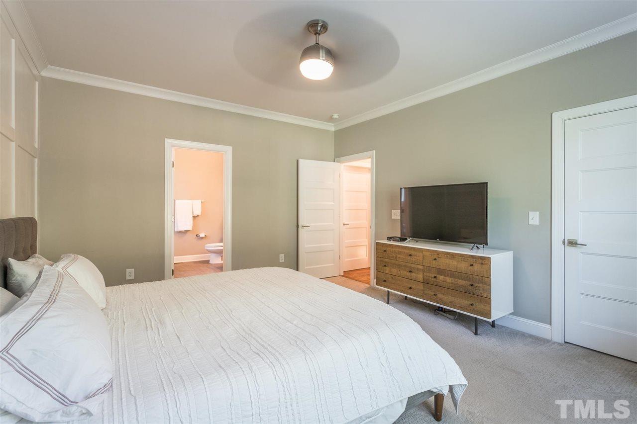 5316 Olive Road Raleigh, NC 27606 - Photo 15 of 29 a bedroom with a bed and a flat tv screen on wall