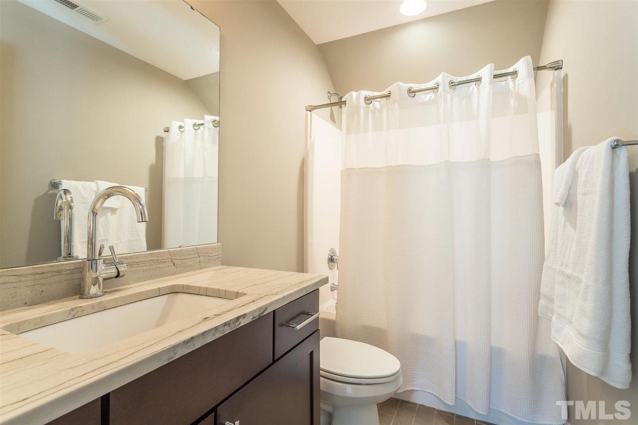 5316 Olive Road Raleigh, NC 27606 - Photo 23 of 29 a bathroom with a granite countertop sink toilet and shower
