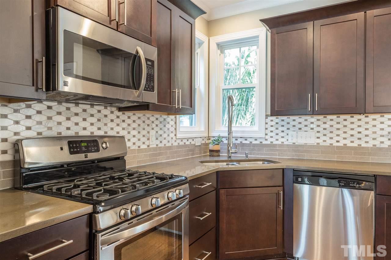 5316 Olive Road Raleigh, NC 27606 - Photo 5 of 29 a kitchen with granite countertop a sink stove and microwave