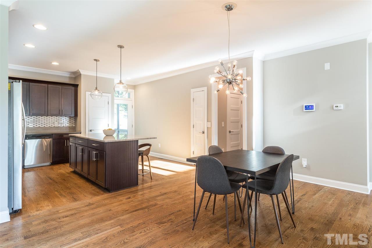 5316 Olive Road Raleigh, NC 27606 - Photo 7 of 29 a kitchen with stainless steel appliances granite countertop a kitchen island hardwood floor sink stove dining table and chairs