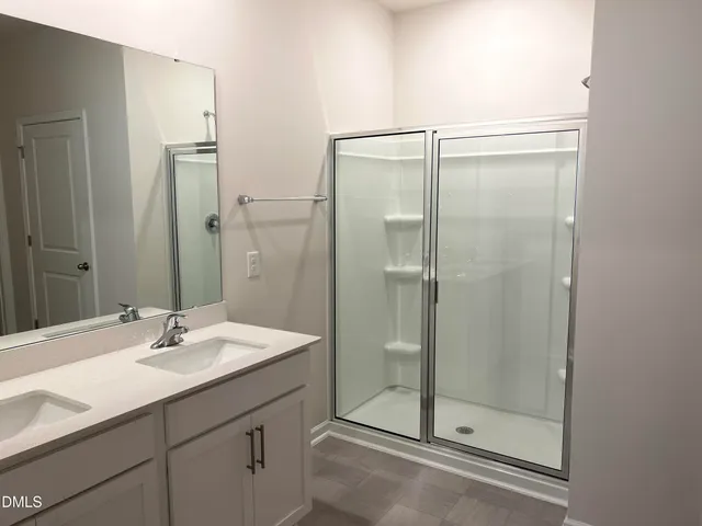 a bathroom with a shower sink and mirror