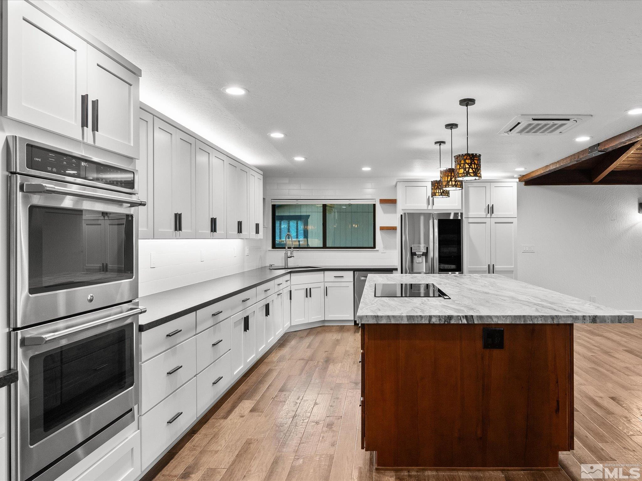 2036 Breen Drive Reno, NV 89509 - Photo 14 of 38 a kitchen with stainless steel appliances kitchen island granite countertop a sink and stove top oven