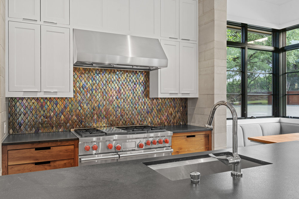 1905 Paisano Road Austin, TX 78746 - Photo 10 of 40 An inviting kitchen with a modern aesthetic features stainless steel appliances and a unique backsplash.