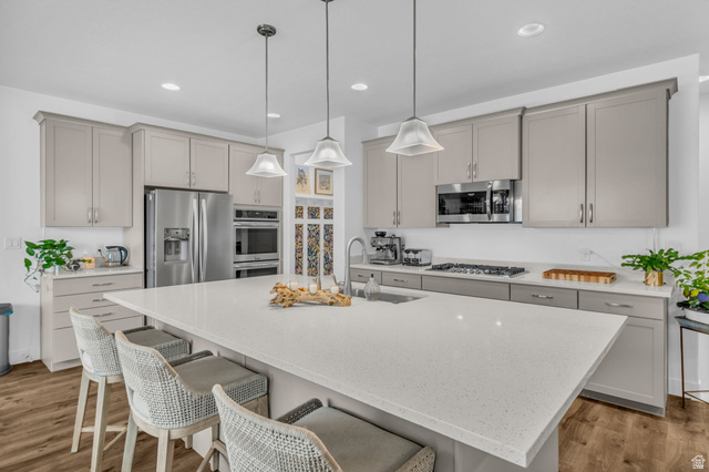 2454 West Jackson Street Mapleton, UT 84664 - Photo 14 of 63 Kitchen featuring a breakfast bar area, light stone counters, stainless steel appliances, and gray cabinets