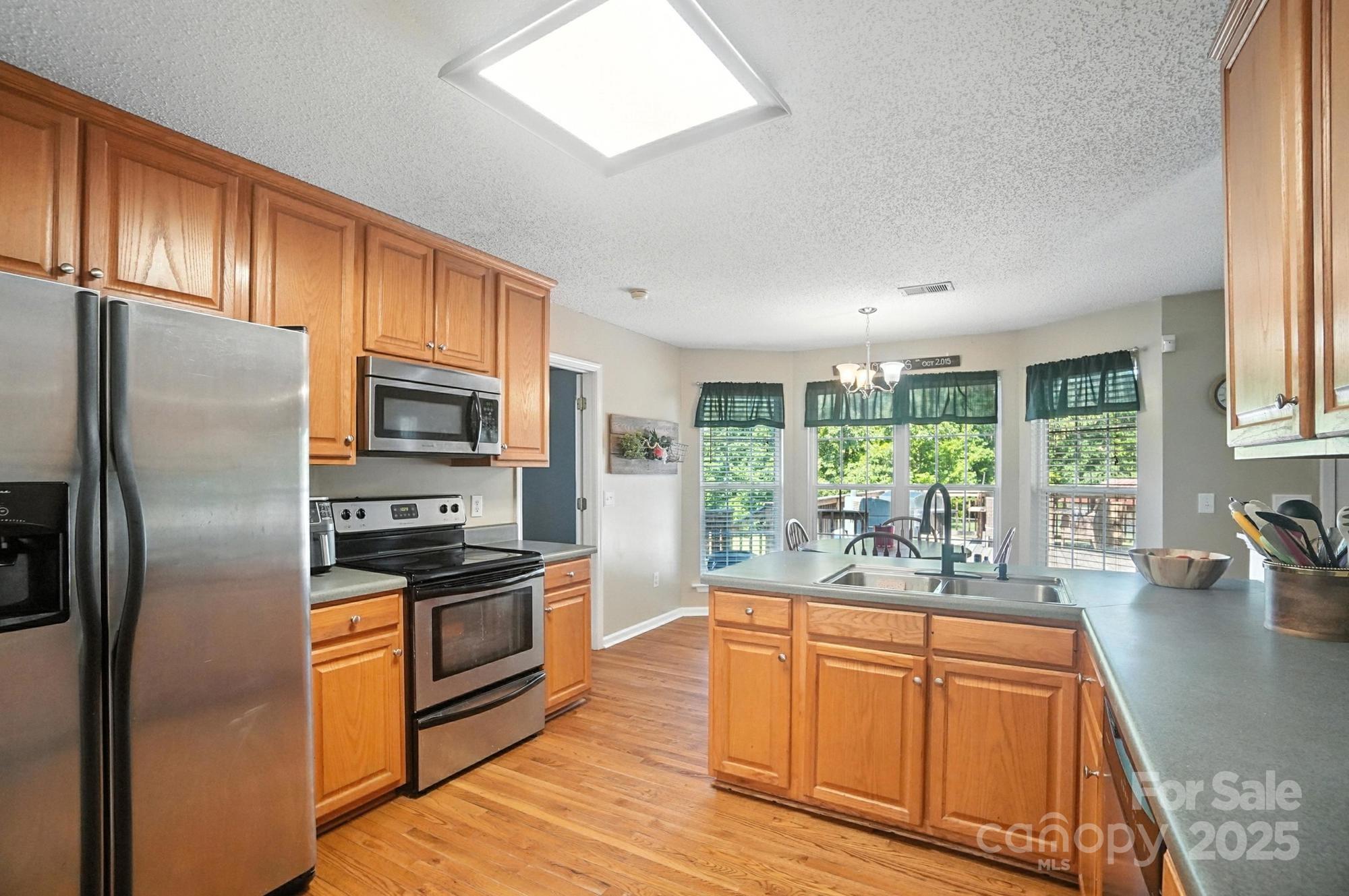 1116 State Rd S-29-770 Kershaw, SC 29067 - Photo 6 of 48 a kitchen with stainless steel appliances granite countertop a refrigerator a stove top oven a sink and dishwasher with wooden floor