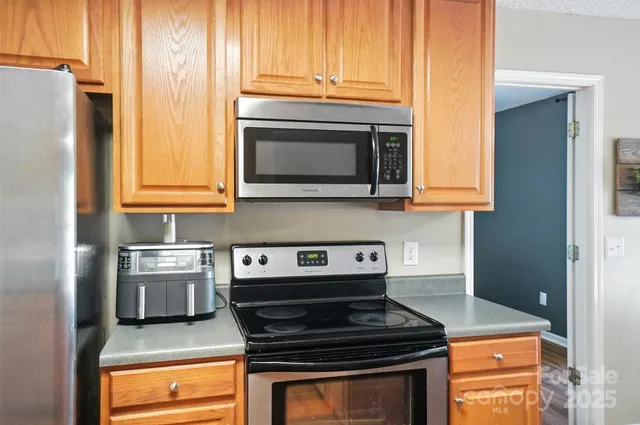 a kitchen with stainless steel appliances granite countertop a stove and a microwave
