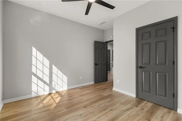 a view of a room with wooden floor and a ceiling fan