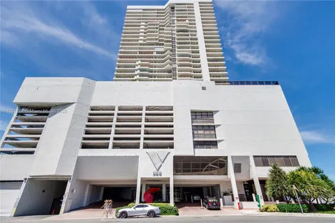 a view of a cars park in front of the building