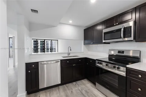 a kitchen with stainless steel appliances a stove sink microwave and cabinets