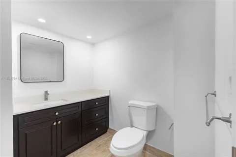 a bathroom with a toilet a sink a mirror and vanity