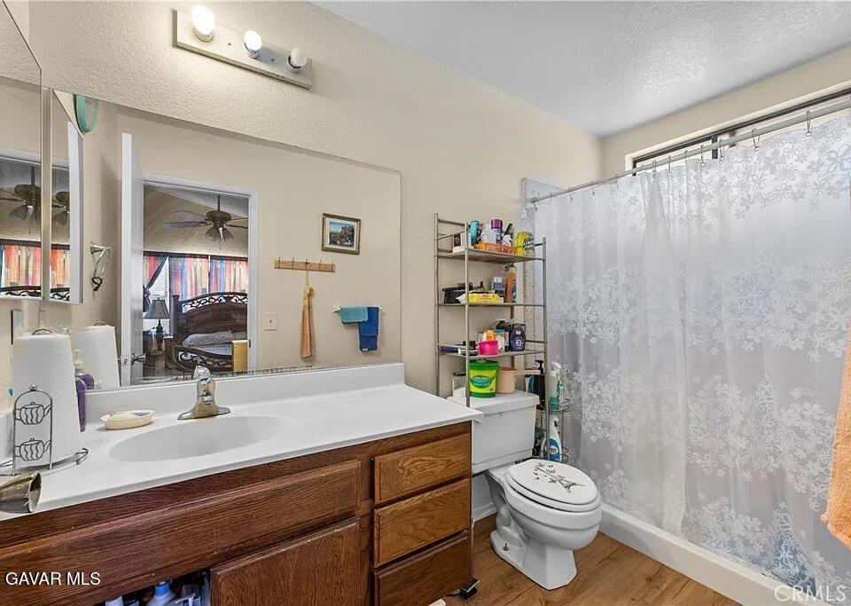 45109 18th Street West Lancaster, CA 93534 - Photo 7 of 9 a bathroom with a sink a toilet and shower curtain