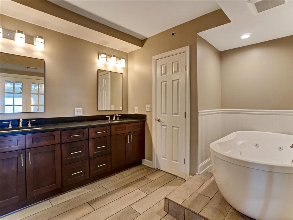 3435 Kingsboro Road Northeast, Unit 1601 Atlanta, GA 30326 - Photo 22 of 54 a spacious bathroom with a tub sink and mirror