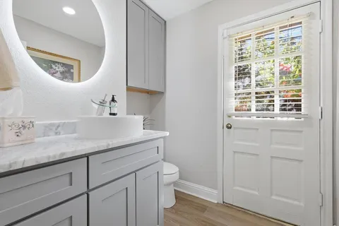 a en suite bathroom with a granite countertop sink and a mirror