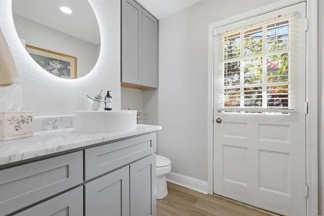 a en suite bathroom with a granite countertop sink and a mirror